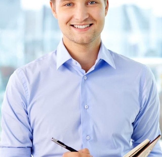 PORTRAIT OF A BUSINESS GUY WRITING IN HIS ORGANIZER