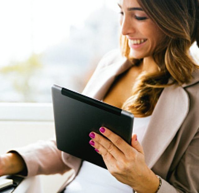 PORTRAIT OF SUCCESSFUL BUSINNESSWOMAN WORKING AT CAFÈ.