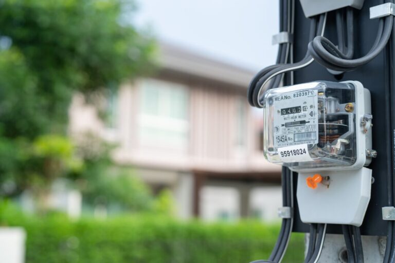Um poste padrão de iluminação pública, composto por aço galvanizado e com design moderno, iluminando a rua à noite."