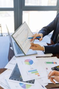 PERSON IN BLACK SUIT JACKET HOLDING WHITE PAPER