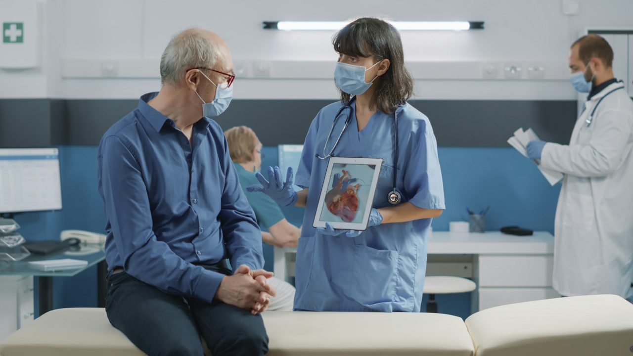 2025 - Início - Home nurse and elder patient looking at cardiology illustration Experienced and Compassionate Team