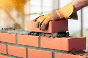 Pedreiro profissional trabalhando em obra com equipamentos de segurança